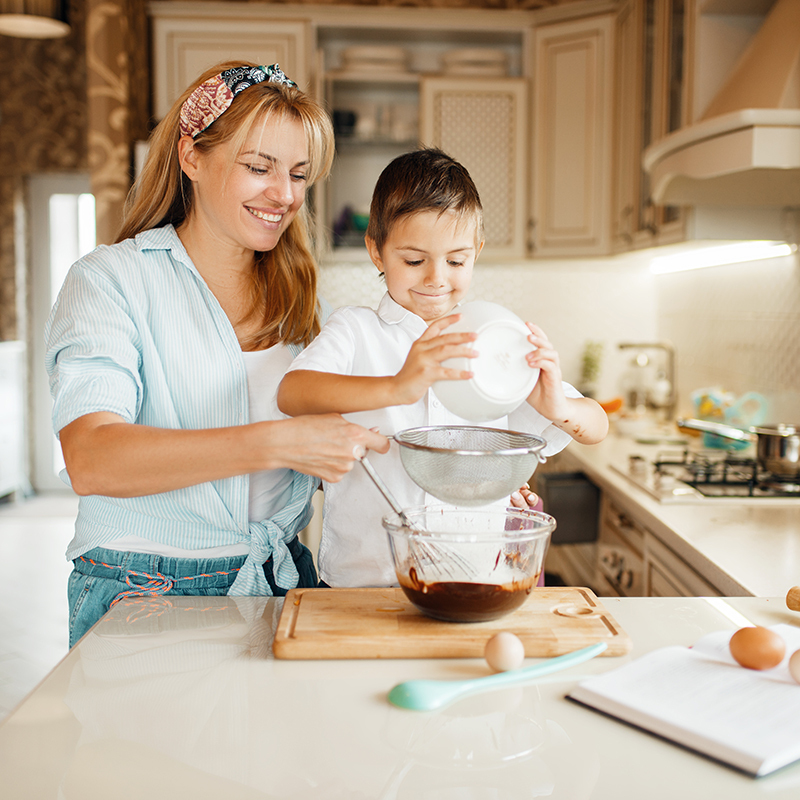 Mãe e filho a misturar chocolate derretido numa tigela